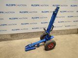 the blue hand truck is parked in front of a wall