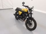 a yellow and black motorcycle parked in a white room