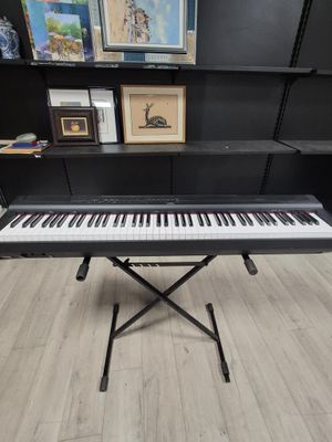 a piano sits on a stand in front of a bookshelf