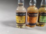 three bottles of whisky are lined up on a white surface