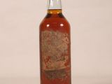 une bouteille de whisky posée sur une surface blanche