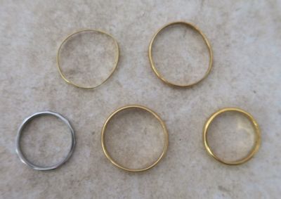 four different types of wedding rings on a marble surface