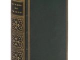 un vieux livre à la couverture noire et aux bordures dorées