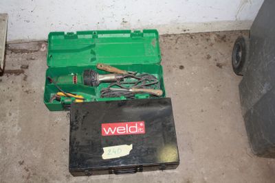 a green tool box with tools in it on the floor