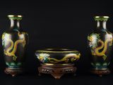 trois vases placés les uns à côté des autres sur un fond noir