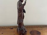 statue of a woman holding a peace sign on a wooden table