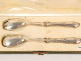 three silver spoons in a box on a table