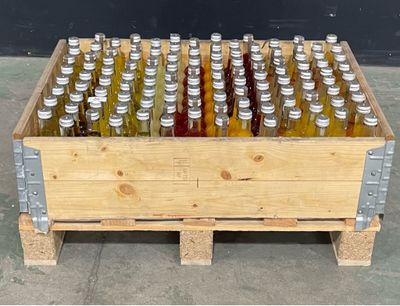 une caisse en bois remplie de bouteilles de vin posée sur un sol en béton