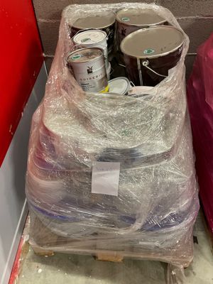 deux seaux de peinture posés sur une palette dans une pièce