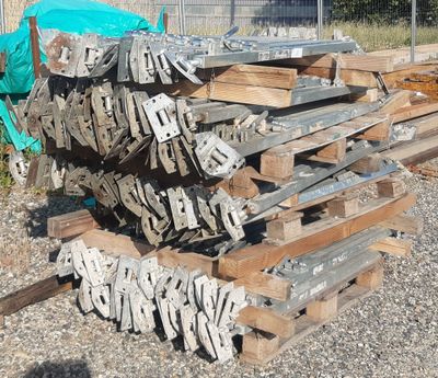 un tas de bois posé par terre près d'une clôture