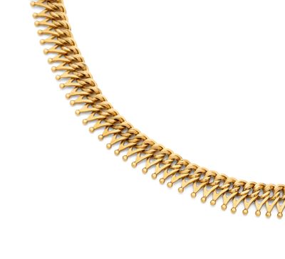gros plan d'un collier en or sur fond blanc