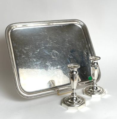 a silver tray with two candles and a mirror on it