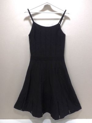 une robe noire suspendue à un cintre contre un mur
