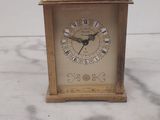 une petite horloge posée sur un plan de travail en marbre