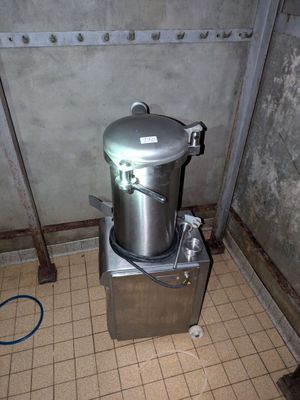 une grande marmite en métal posée sur une petite machine