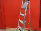 a ladder that is leaning against a red wall