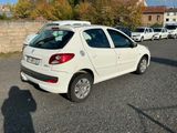 a white car parked in a parking lot next to a brick wall