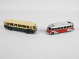 two toy buses sitting next to each other on a white surface