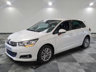 Une Citroën blanche est garée sur un sol carrelé à damier