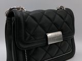 the small black bag is sitting on a white surface