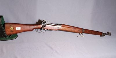 the rifle is laying on a white surface with a wooden handle