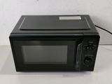 a black microwave oven sitting on a white table
