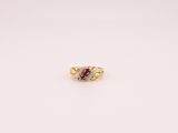 gros plan d'une bague en or avec une pierre rouge