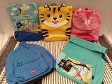 four bags of different colors and designs on a bed