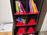 a book shelf with a clock on top of it