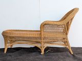 a wicker chaise with a wooden frame on the floor