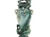 un vase vert orné d'un dragon, posé sur un socle