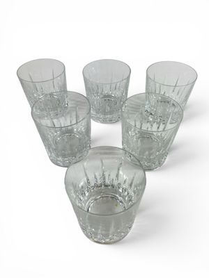 six verres à pied en verre transparent posés sur une surface blanche
