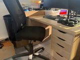 a desk with two computer monitors and a chair in front of it