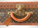 a brown and tan suitcase with a brown tag on it