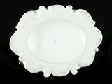 a white plate with a blue center on a black surface