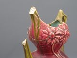 un vase rose orné d'un motif floral