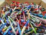 une boîte remplie de stylos et de crayons posée sur une table