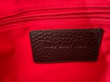 a close up of a red bag with a black label on it