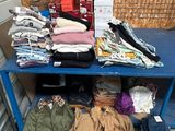 une table bleue sur laquelle sont posés de nombreux vêtements et chapeaux