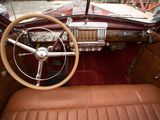 dashboard of a classic car with a steering wheel and leather seats