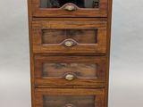 une commode ancienne en bois, avec des portes vitrées et des tiroirs
