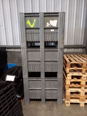 Plusieurs palettes de bois sont empilées dans une zone de stockage