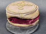 a small hat with a gold design on top of it