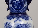 a blue and white vase sitting on top of a wooden table