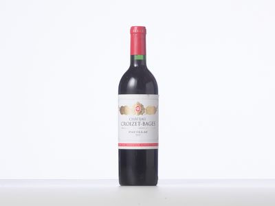 a bottle of red wine sitting on top of a white table