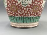 un vase rouge et vert posé sur une table