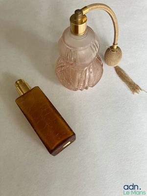 un petit flacon de parfum à côté d'un autre petit flacon de parfum