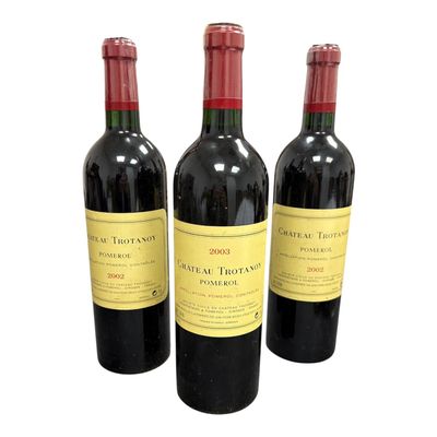 three bottles of red wine sitting next to each other on a white surface