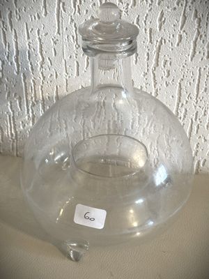 un vase en verre transparent muni d'un couvercle, posé sur une table