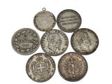 six silver coins are arranged in a circle on a white surface